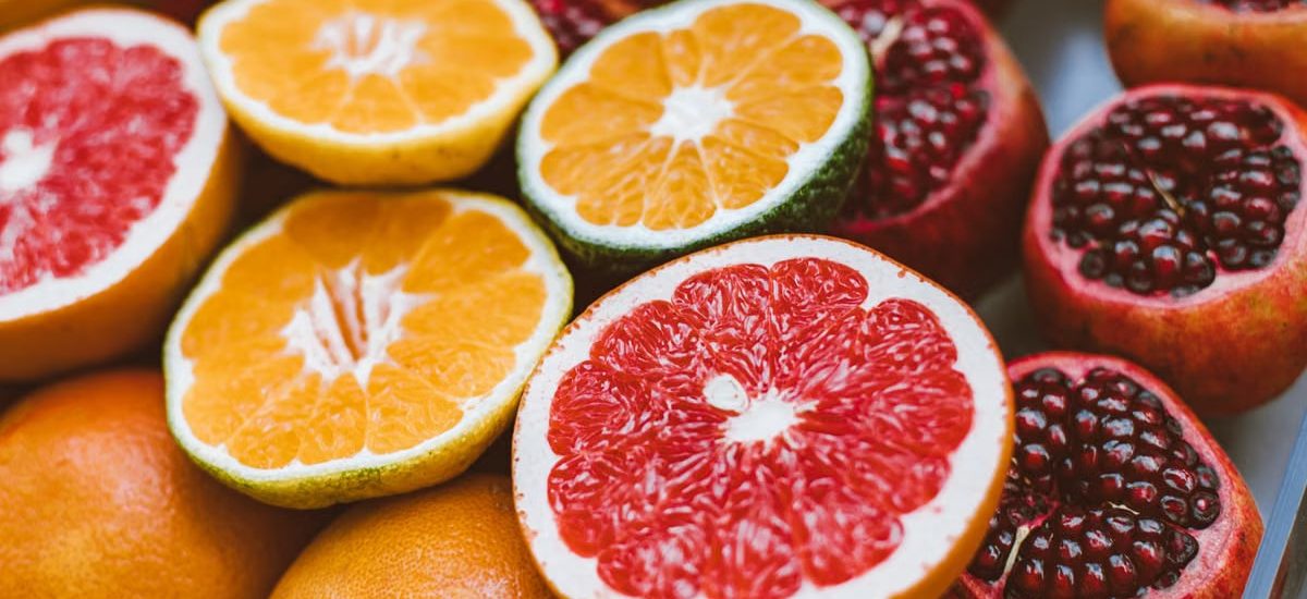 Vibrant close-up of sliced citrus fruits and pomegranates showcasing freshness and variety.