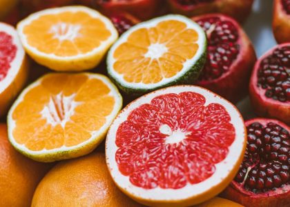 Vibrant close-up of sliced citrus fruits and pomegranates showcasing freshness and variety.