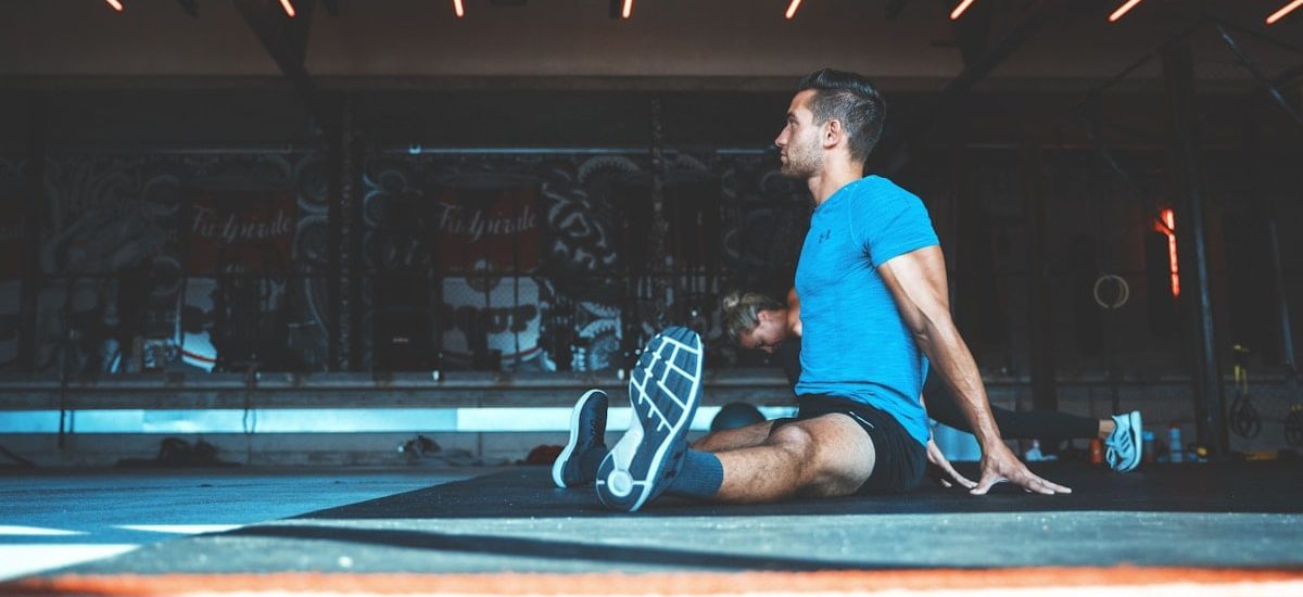 man sitting on exercise mat